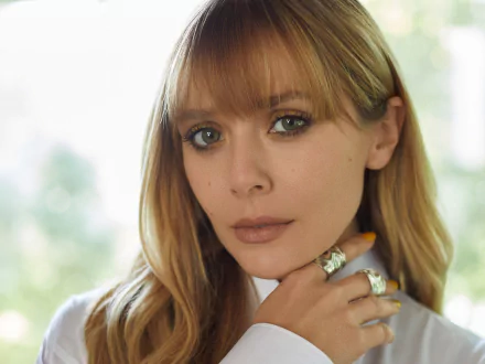 HD PC desktop wallpaper: close-up portrait of a female celebrity with blonde bangs, soft natural light, neutral makeup, hand near chin and a calm, contemplative expression.