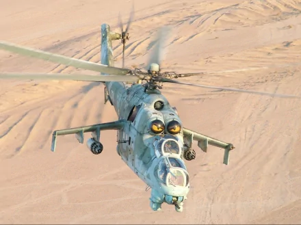 HD PC desktop wallpaper showing a Polish Army Mil Mi-24 attack helicopter in flight over a sandy desert, front-angle view with rotors turning and weapon pods visible.