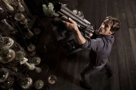 Stephen Moyer wields a weapon in a dramatic scene from the movie Priest. This HD wallpaper captures an intense moment against a backdrop of unique glass vessels.