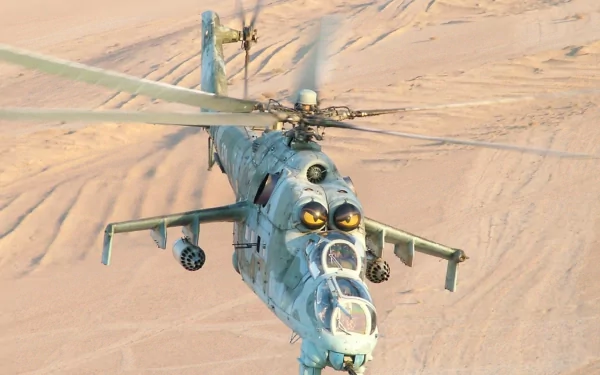 HD PC desktop wallpaper showing a Polish Army Mil Mi-24 attack helicopter in flight over a sandy desert, front-angle view with rotors turning and weapon pods visible.