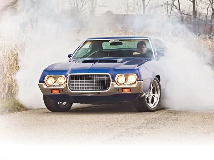 HD desktop wallpaper featuring a Ford Gran Torino Sport in motion, surrounded by tire smoke on a rural road.