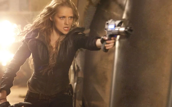 A high-definition wallpaper from the movie I Am Number Four, featuring a fierce female character aiming a futuristic weapon in a dramatic setting.