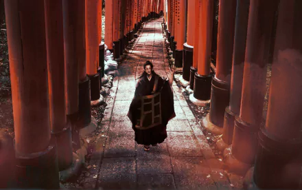 HD PC desktop wallpaper featuring Suguru Geto from the anime Jujutsu Kaisen walking through a vibrant red torii gate pathway.