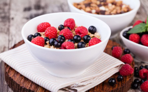 A delicious breakfast spread featuring fluffy pancakes, crispy bacon, and fresh berries on a rustic wooden table, perfect for a morning wallpaper.