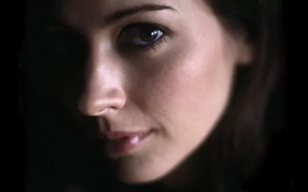 HD desktop wallpaper featuring a close-up of a woman's face in soft lighting. The image captures Amy Acker's striking features with a blend of shadows and highlights.