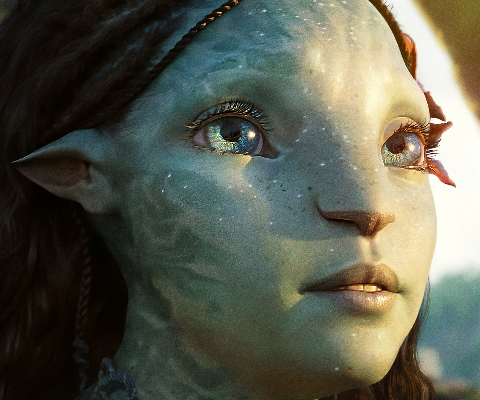 Close-up of a Na'vi from Avatar: The Way of Water — blue-green skin, luminous eyes and water-speckled markings; HD PC desktop wallpaper/background.