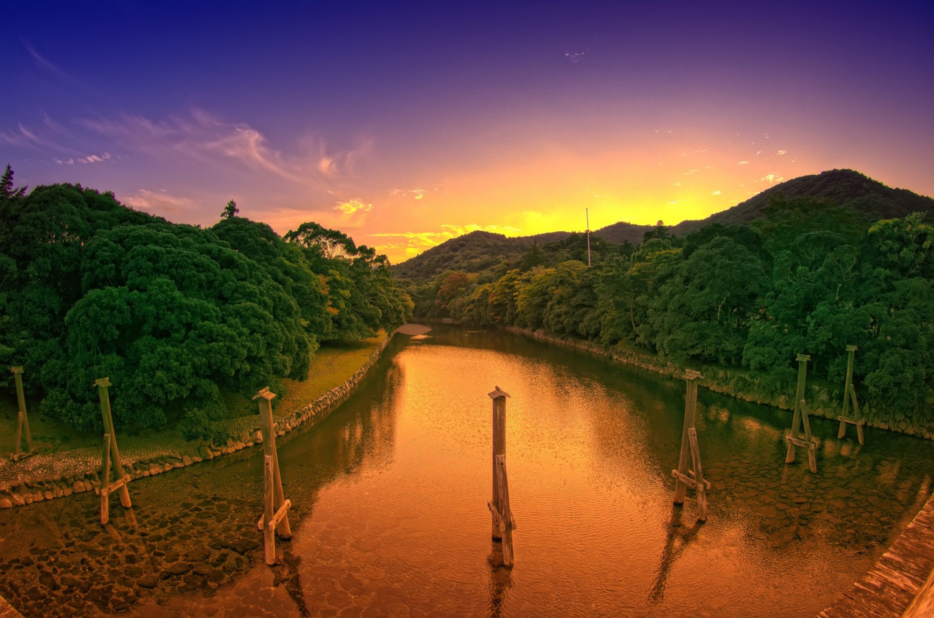 HD desktop wallpaper featuring a serene river winding through lush green hills under a vibrant sunset sky, showcasing the beauty of nature.