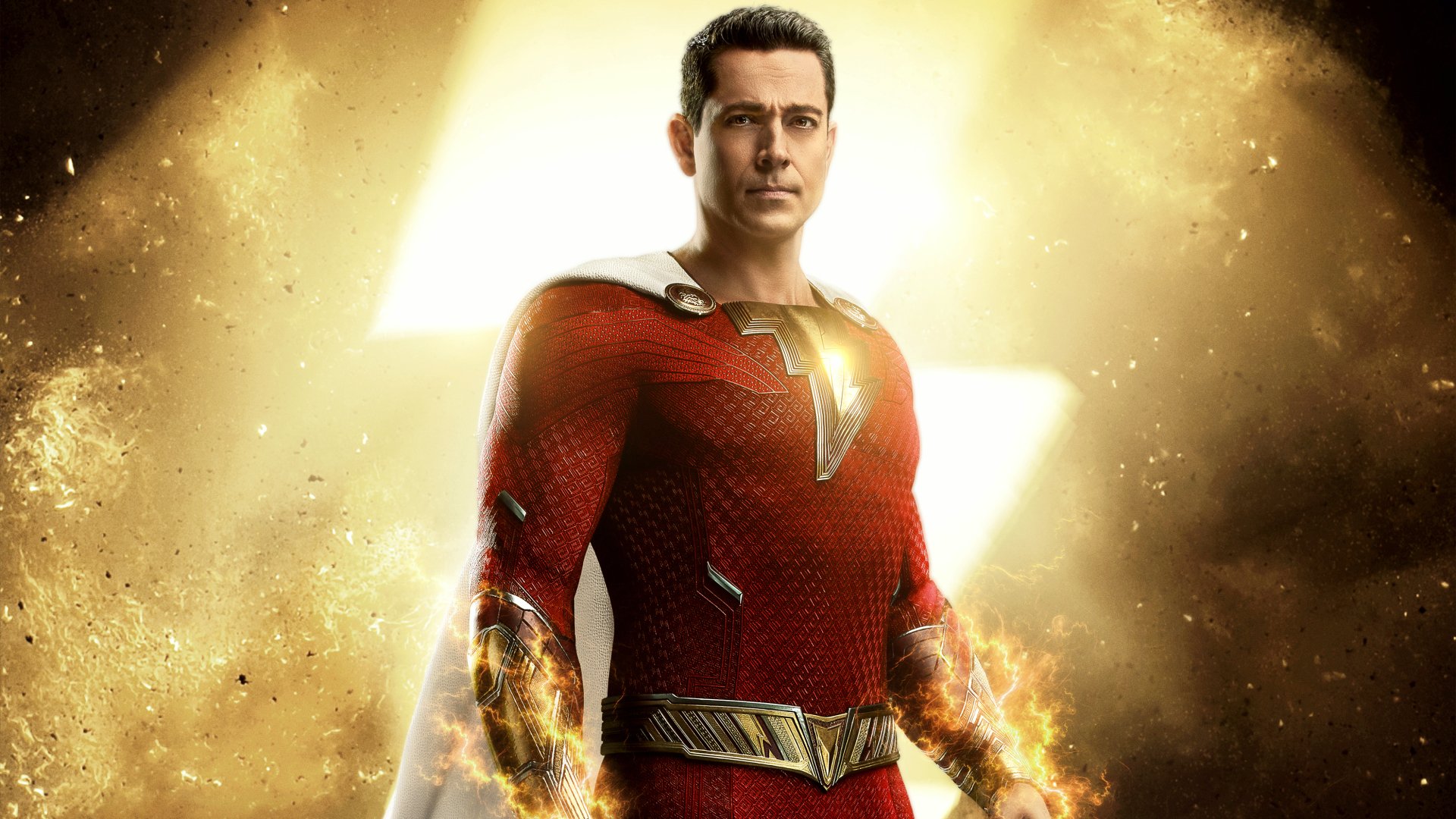 Shazam in a red suit with a glowing lightning emblem and crackling energy in his fists against a golden burst — 2K Quad HD PC desktop wallpaper from Shazam! Fury of the Gods.