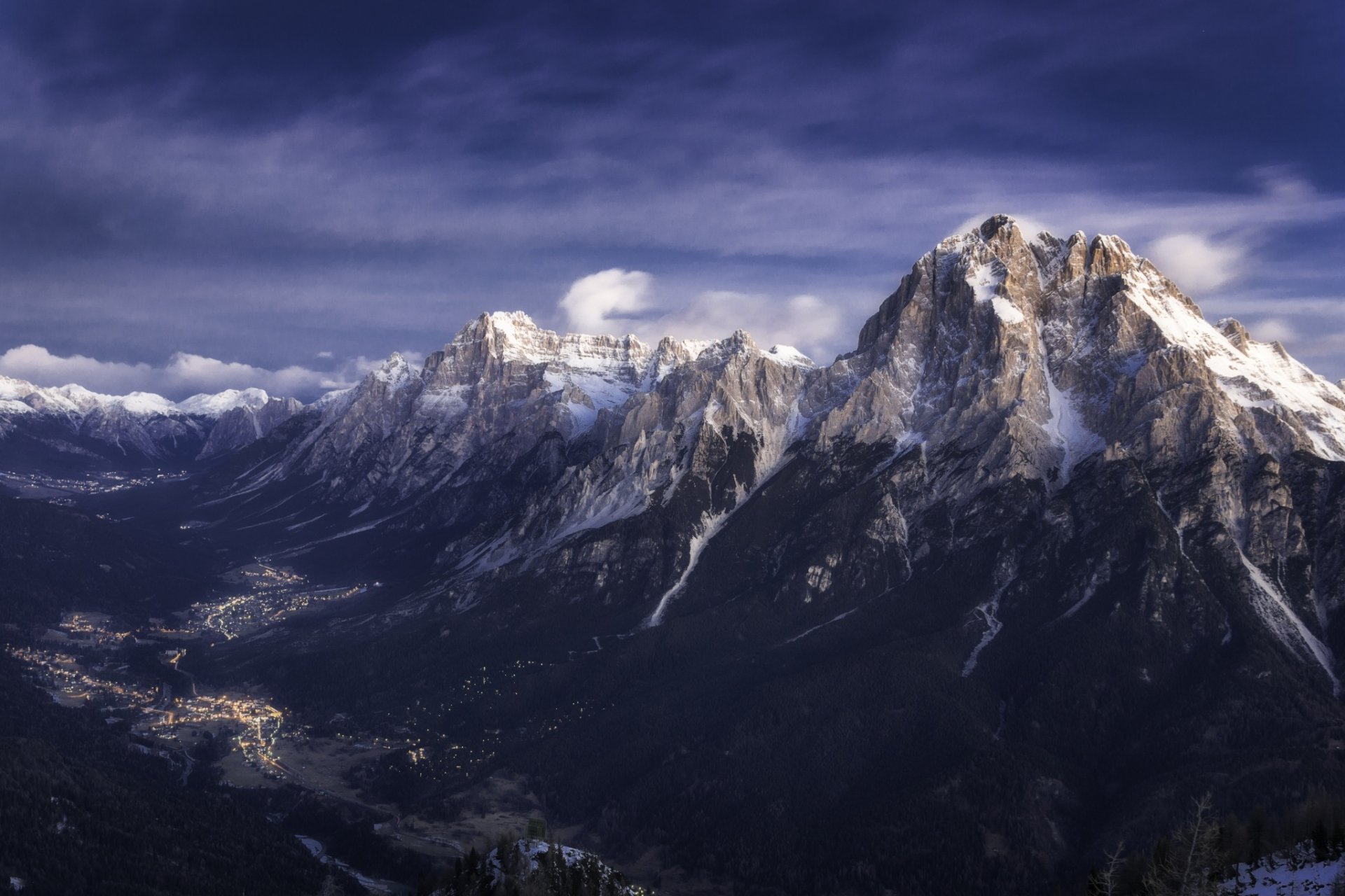 HD PC desktop wallpaper showcasing a breathtaking mountain range with snow-capped peaks overlooking a serene valley under a dramatic sky.