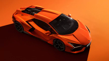 4K Ultra HD PC desktop wallpaper featuring an orange Lamborghini Revuelto sports vehicle against an orange background.