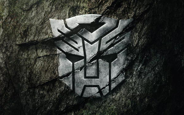 HD PC desktop wallpaper featuring the Autobot emblem carved into a rocky surface from the movie Transformers: Rise of the Beasts.