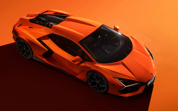 4K Ultra HD PC desktop wallpaper featuring an orange Lamborghini Revuelto sports vehicle against an orange background.