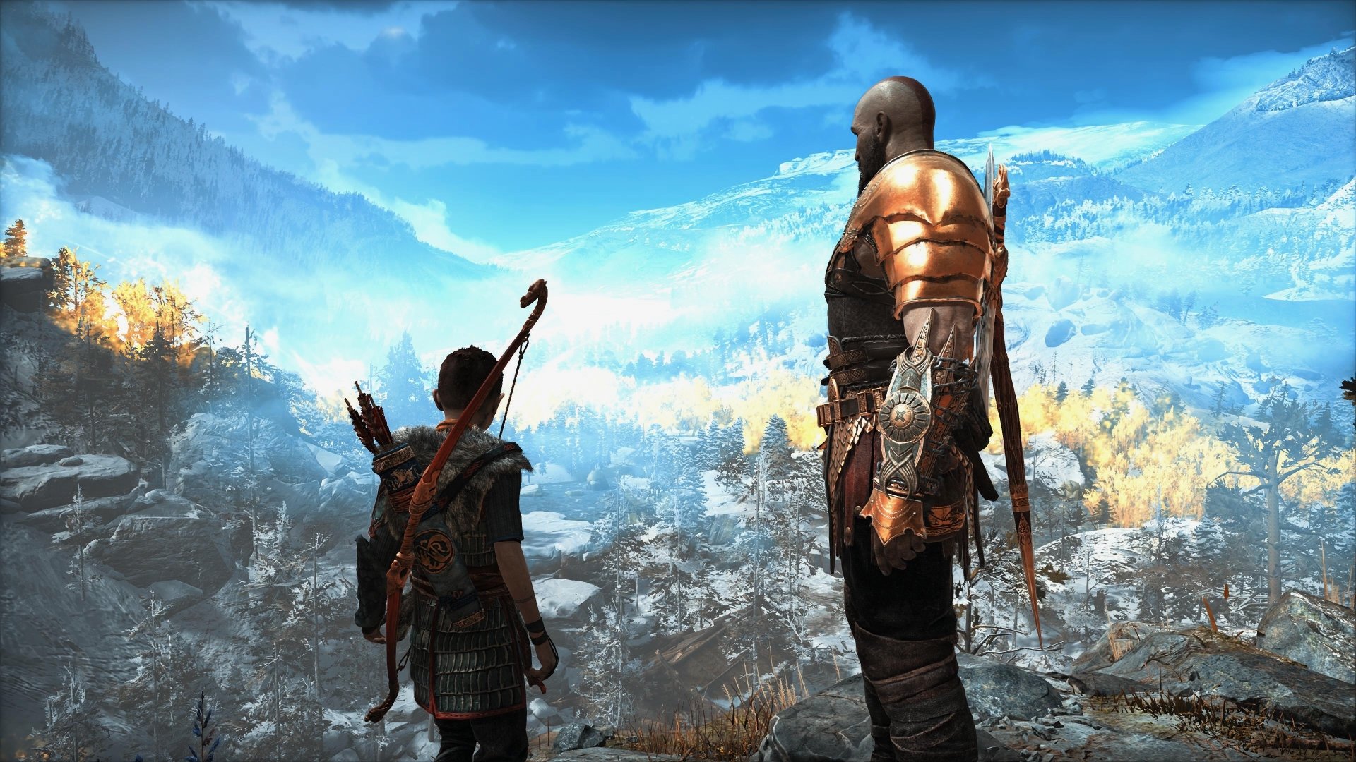 Kratos and Atreus from God of War stand overlooking a vast, mountainous landscape under a bright blue sky in this 4K Ultra HD PC desktop wallpaper.
