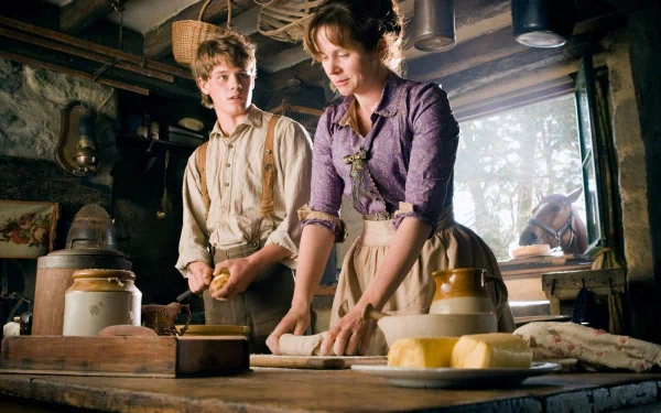 HD desktop wallpaper from the movie War Horse, showing two characters in period clothing preparing food inside a rustic kitchen.