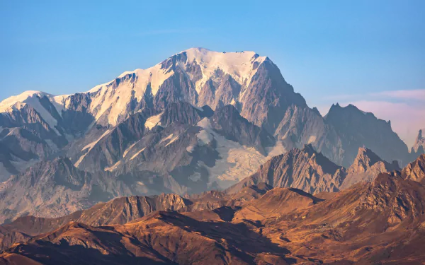 HD desktop wallpaper showcasing Mont Blanc towering above the rugged Alps under a clear blue sky, highlighting the majestic beauty of nature.