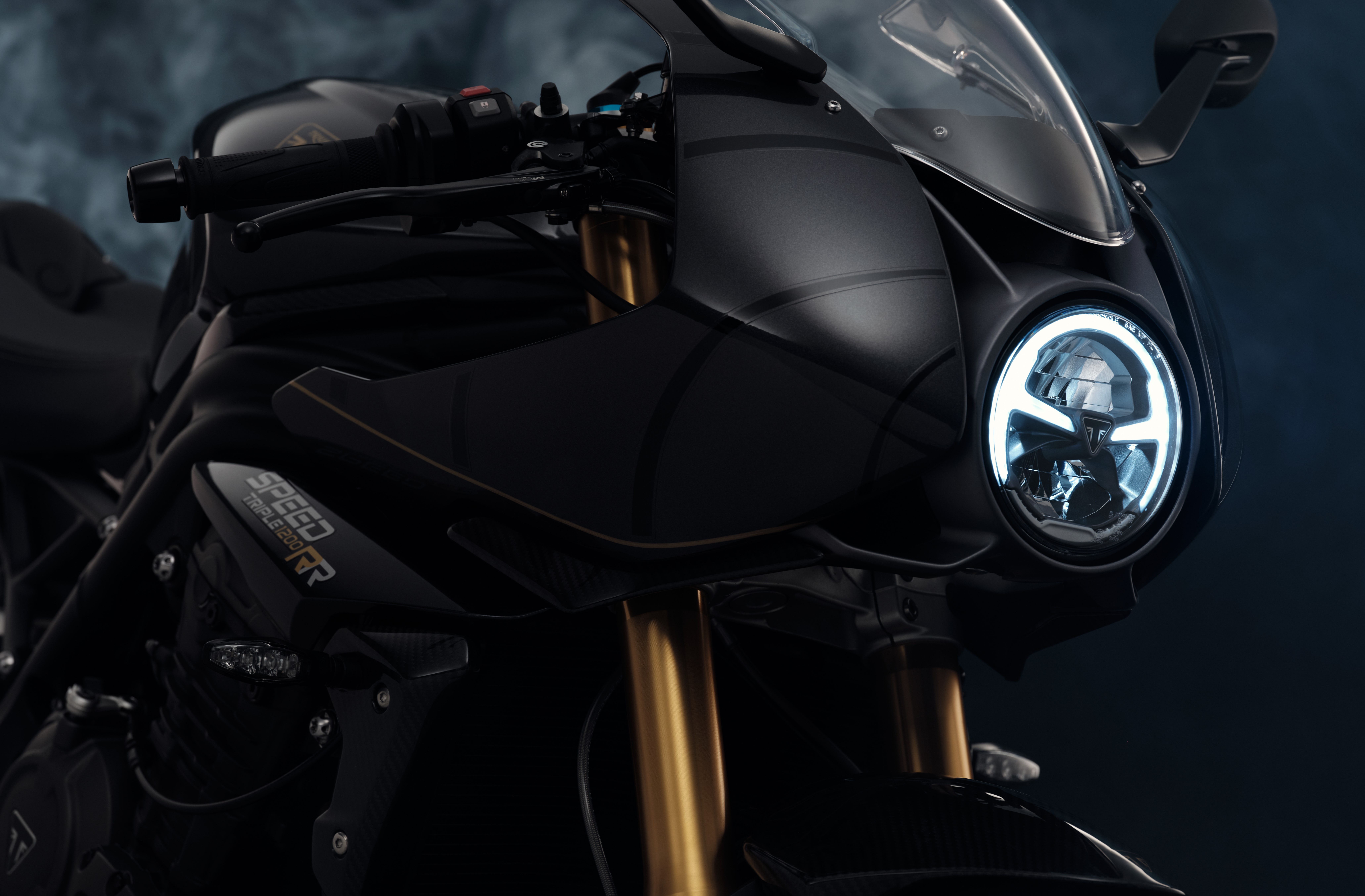 Triumph Speed Triple 1200 RR Bond Edition motorcycle showcased as a stylish HD desktop wallpaper with a focus on its sleek black design and distinctive headlight.