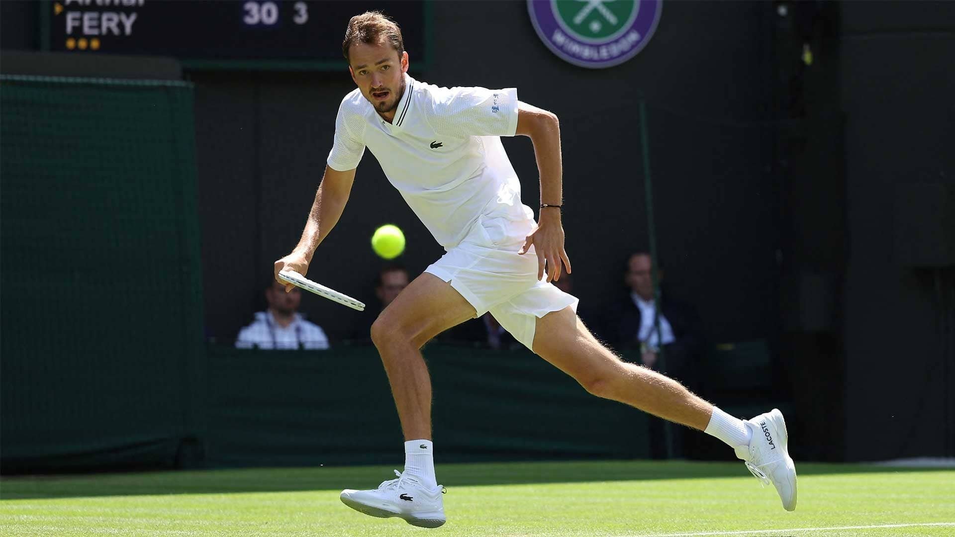 Daniil Medvedev competes at Wimbledon 2023, skillfully returning a tennis ball on the green court, making for an energizing sports wallpaper.