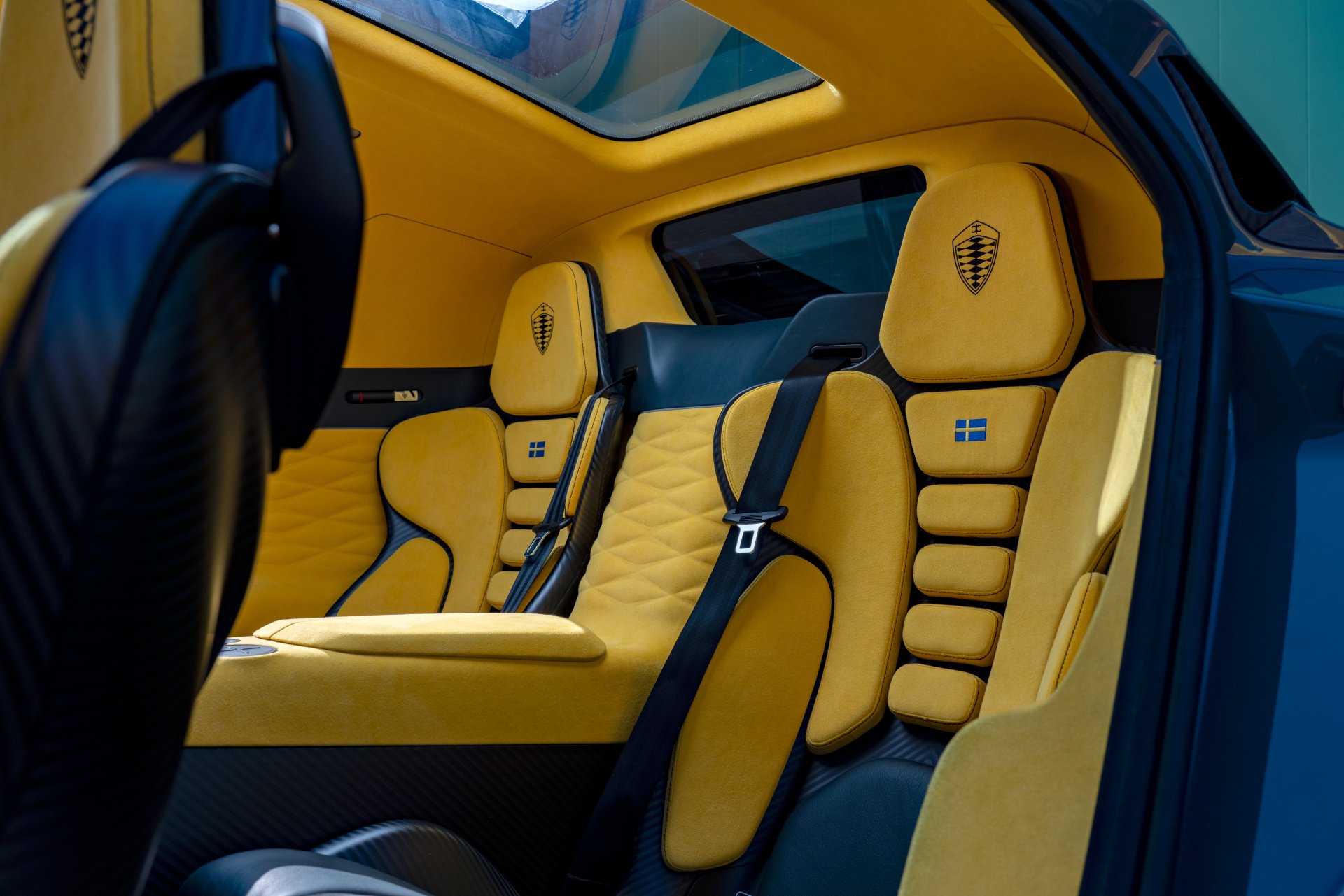 Interiors of a Koenigsegg Gemera featuring sleek design and striking yellow and black accents, showcased as a high-definition desktop wallpaper.