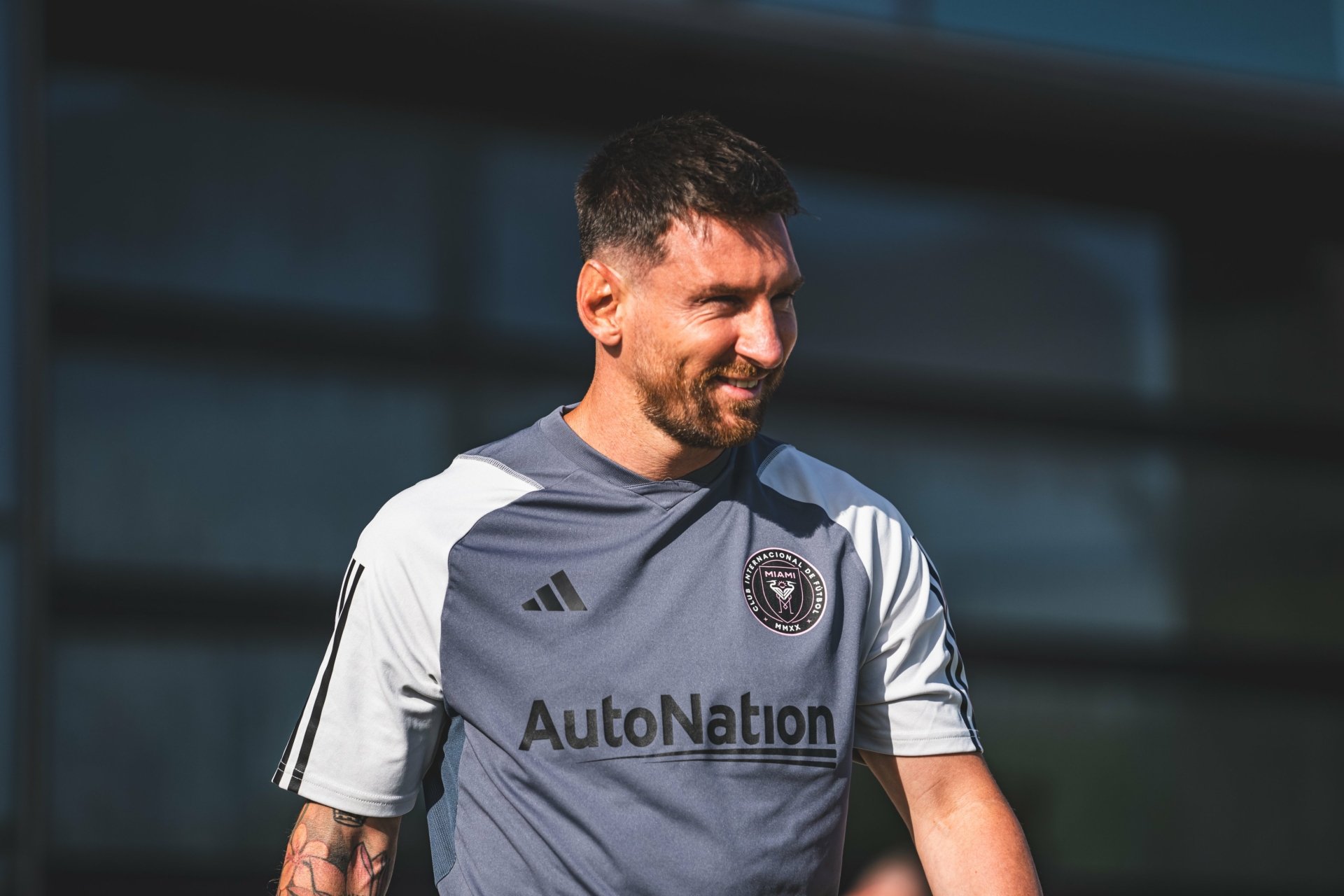 Lionel Messi smiles during a training session with Inter Miami CF, captured in an HD desktop wallpaper showcasing his dedication to the sport.