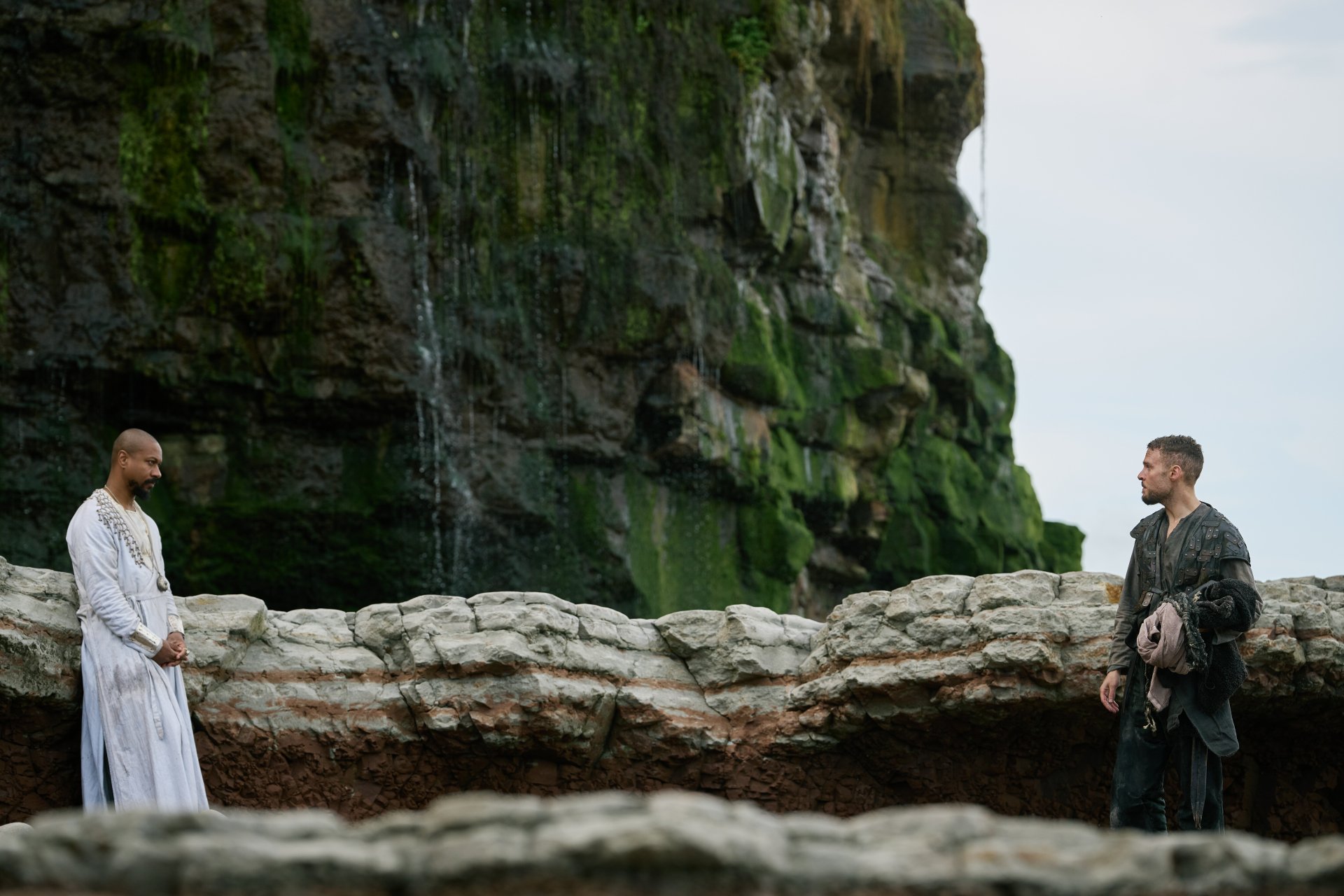HD desktop wallpaper of 'The Winter King' featuring two figures clad in medieval attire standing near a cliff with a waterfall in the background.