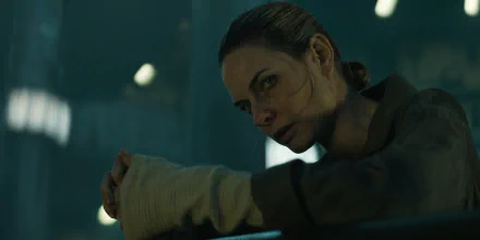 HD wallpaper featuring a close-up scene of a combat-ready woman in a silo environment, emoting intensity and focus.