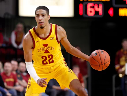 Tyrese Haliburton dribbles a basketball on the court, showcasing his athleticism in a vibrant Iowa State jersey. This HD wallpaper captures the essence of sports action.