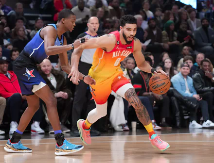 HD desktop wallpaper featuring NBA player Jayson Tatum in an orange All-Star jersey, dribbling past a defender during a game.