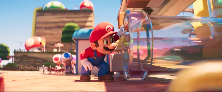HD desktop wallpaper from the 2023 movie Super Mario Bros. featuring Mario interacting with a clear, cylindrical device in a vibrant Mushroom Kingdom setting.