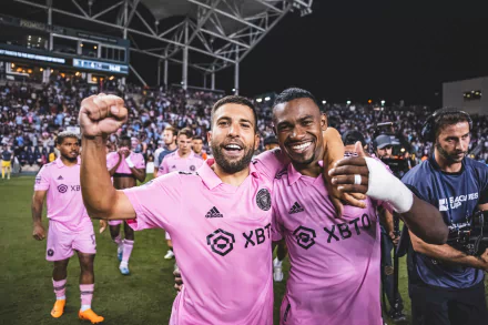 Two Inter Miami CF players celebrating a victory on the field, HD desktop wallpaper featuring pink jerseys and stadium background.