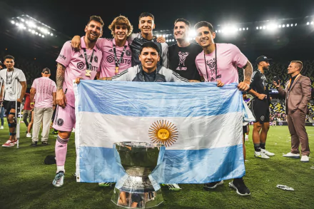 HD wallpaper featuring Inter Miami CF players celebrating a victory, with the centerpiece being a person proudly holding an Argentine flag draped over a trophy, symbolizing triumph and national pride.