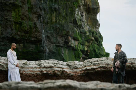HD desktop wallpaper of 'The Winter King' featuring two figures clad in medieval attire standing near a cliff with a waterfall in the background.