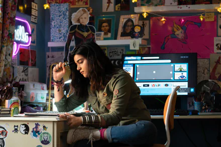 HD desktop wallpaper featuring Iman Vellani in a scene from The Marvels, with vibrant superhero posters and neon lights.