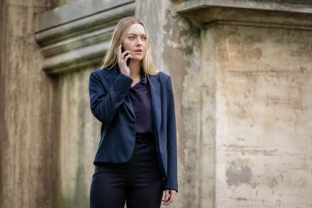 Dakota Fanning is shown in an intense moment on the phone, dressed in a tailored suit, from her role in the movie The Equalizer 3. A captivating HD desktop wallpaper.