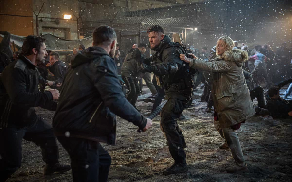 Action-packed scene from the movie Extraction 2 featuring Chris Hemsworth and Tinatin Dalakishvili amidst chaos and snowfall, set as a high-definition desktop wallpaper.