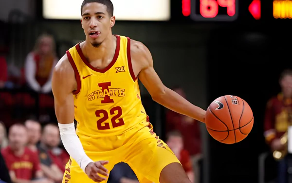 Tyrese Haliburton dribbles a basketball on the court, showcasing his athleticism in a vibrant Iowa State jersey. This HD wallpaper captures the essence of sports action.