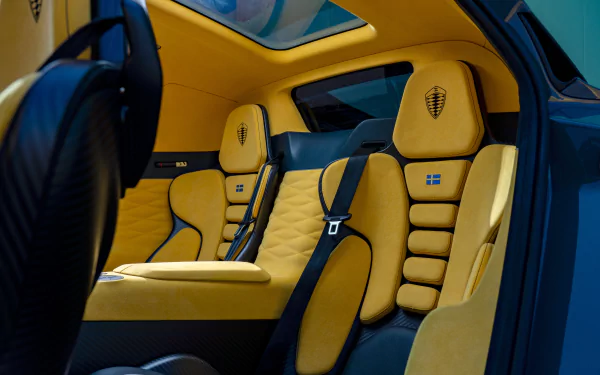 Interiors of a Koenigsegg Gemera featuring sleek design and striking yellow and black accents, showcased as a high-definition desktop wallpaper.