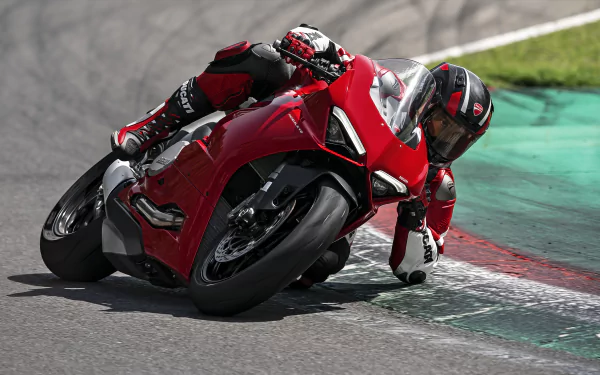 A rider leans into a curve on a Ducati Panigale V2, showcasing the motorcycle's sleek design and dynamic performance on the racetrack. HD desktop wallpaper and background.