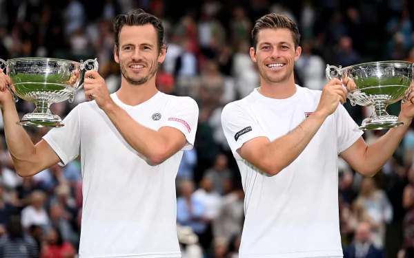 Neal Skupski and Wesley Koolhof celebrate their victory at Wimbledon 2023, holding their trophies aloft amidst an enthusiastic crowd, capturing the essence of tennis success.