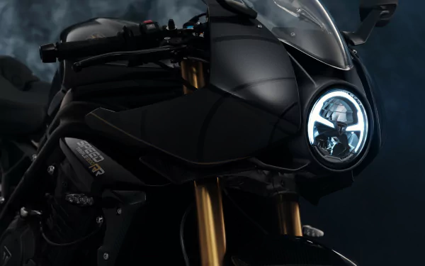 Triumph Speed Triple 1200 RR Bond Edition motorcycle showcased as a stylish HD desktop wallpaper with a focus on its sleek black design and distinctive headlight.