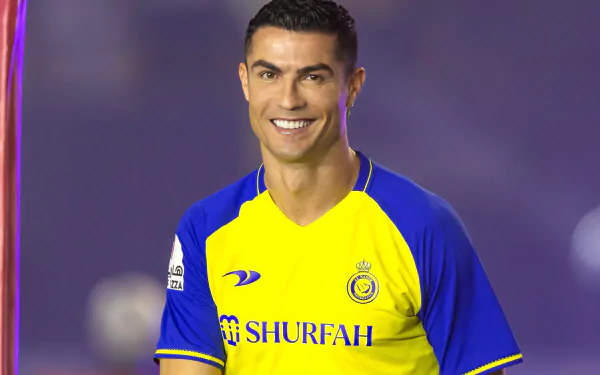 HD desktop wallpaper featuring Cristiano Ronaldo in a yellow soccer jersey, smiling against a blurred purple background, perfect for sports enthusiasts.