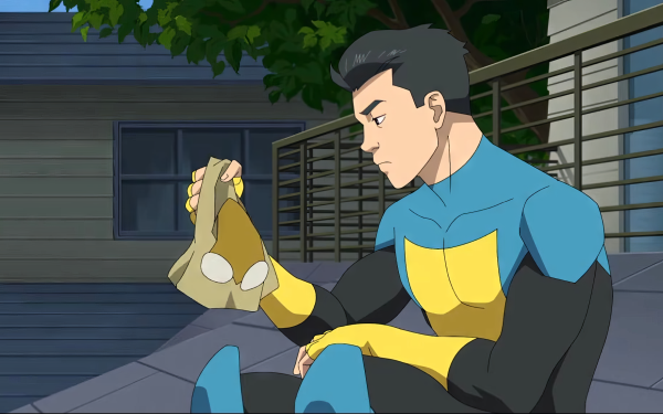 HD wallpaper of Invincible (Mark Grayson) from Image Comics, sitting pensively on steps in costume.