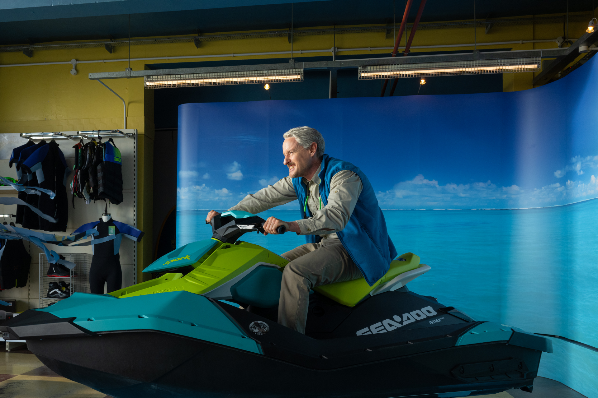 HD desktop wallpaper featuring a male character on a jet ski simulator with a vibrant beach background, tagged with Loki and Owen Wilson themes.
