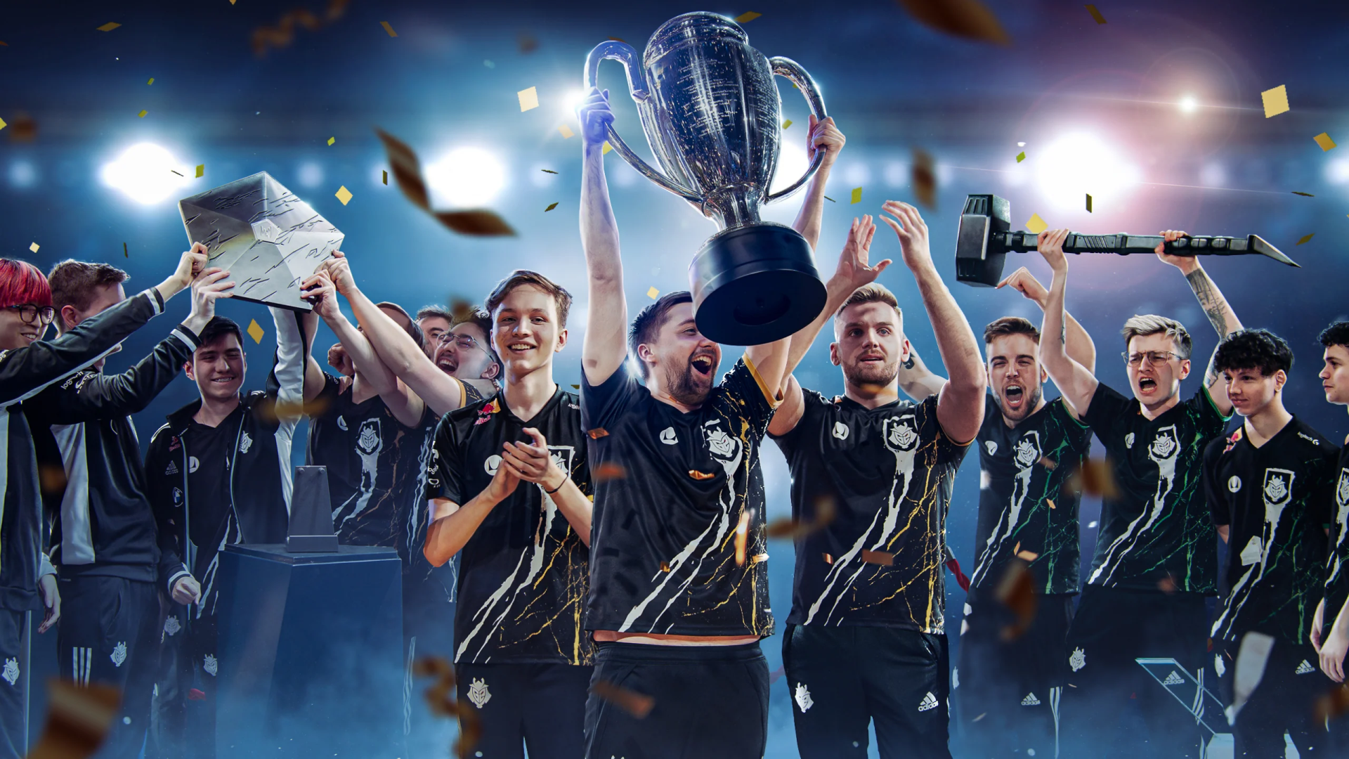 G2 Esports team celebrates victory, lifting a trophy amidst confetti and cheers, capturing the excitement of competitive gaming in this vibrant HD desktop wallpaper.