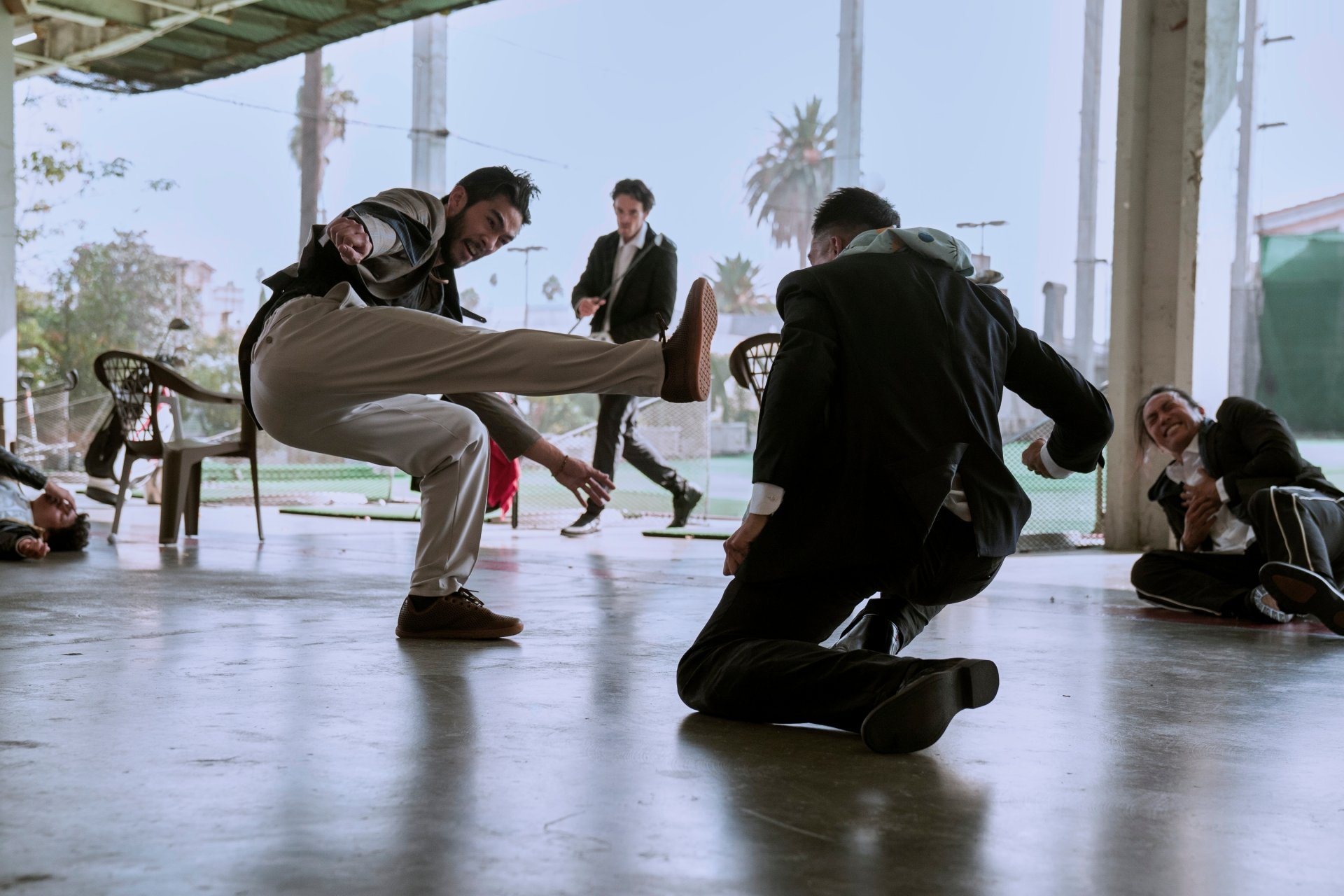 A dynamic scene from the TV show The Brothers Sun, featuring intense action as characters engage in a dramatic confrontation in an urban setting. HD desktop wallpaper.