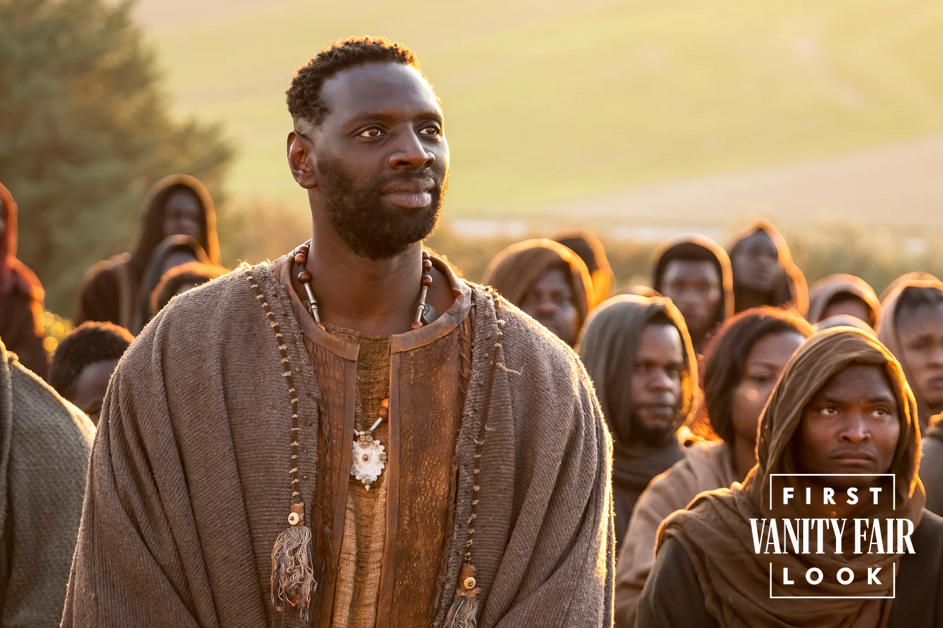 HD wallpaper of a scene from the movie 'The Book of Clarence' with a focused man in the foreground and a group of people in the background, as part of Vanity Fair's first look.