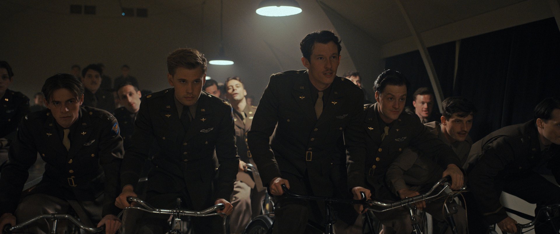 Scene from Masters of the Air TV show featuring uniformed characters on bicycles, available as HD desktop wallpaper and background.