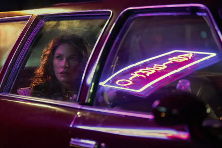 HD desktop wallpaper featuring a scene from the 2024 TV show Griselda, with a character inside a car, neon signs reflected on the window.