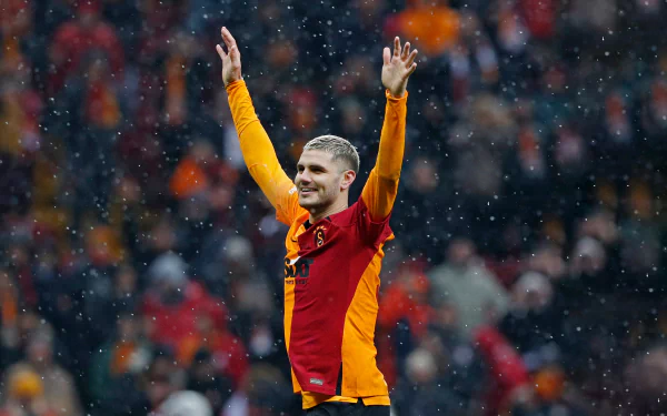 Soccer player raising hands in celebration on the field with a cheering crowd in the background - HD sports wallpaper.