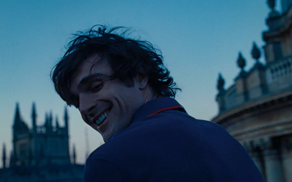 HD desktop wallpaper featuring a scene from the movie Saltburn (2023) with a smiling male character in the foreground and historic architecture in the twilight background.