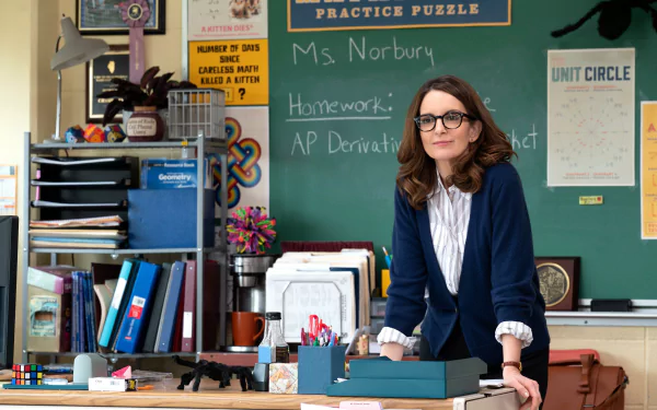 HD desktop wallpaper from Mean Girls (2024) featuring a character in a classroom setting with educational posters in the background.